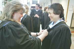 beesons-hhs-retire-2008061 Sue Beeson (right), retiring as Hazen High School principal, gets a final adjustment of her robes from Science Department Chairwoman Teresa Coda before the last commencement exercise she presided over June 13 at Meydenbauer Center. Photo by Greg Farrar