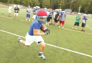 football-LHS-lemmon-2009082 Anthony Lemmon, of Liberty, runs the ball after a handoff from scrimmage during a football team practice. By Greg Farrar