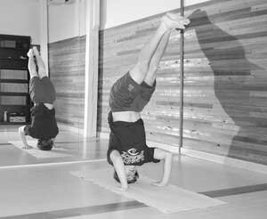 hotyoga-LHS-football-200911 Liberty High School running back Kyle Aherns does a headstand at Issaquah Hot Yoga. Although the temperature soars past 100 degrees in the studio, Aherns keeps his focus. By Tim Pfarr